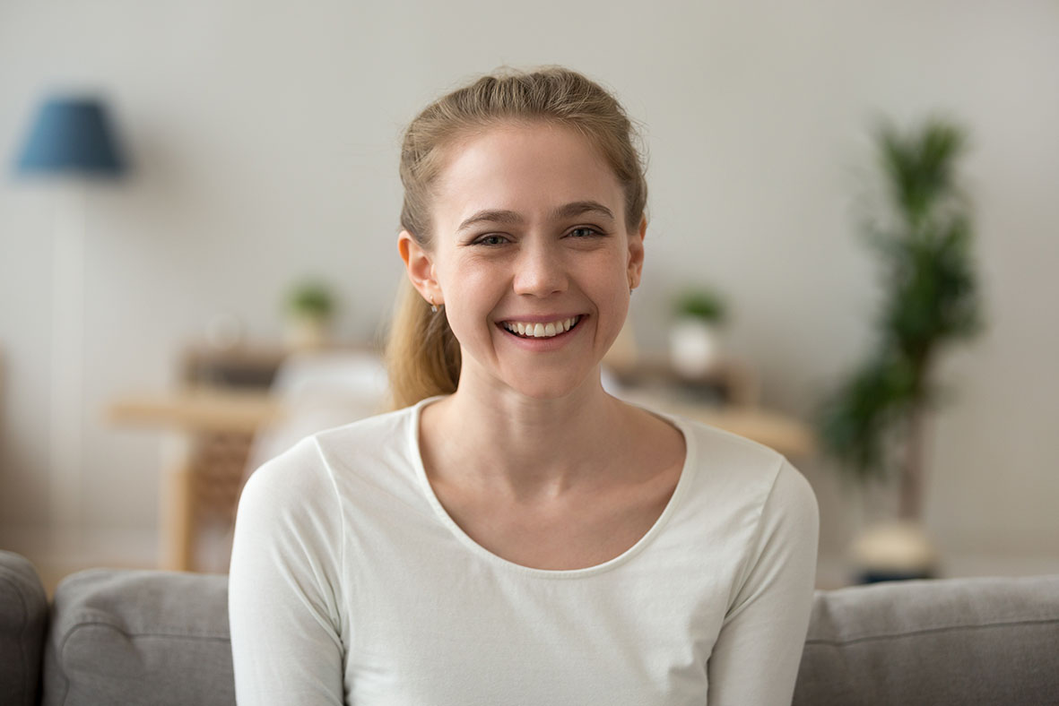 Image of a young white woman with blonde hair smiling.  Her head and shoulders are in view.